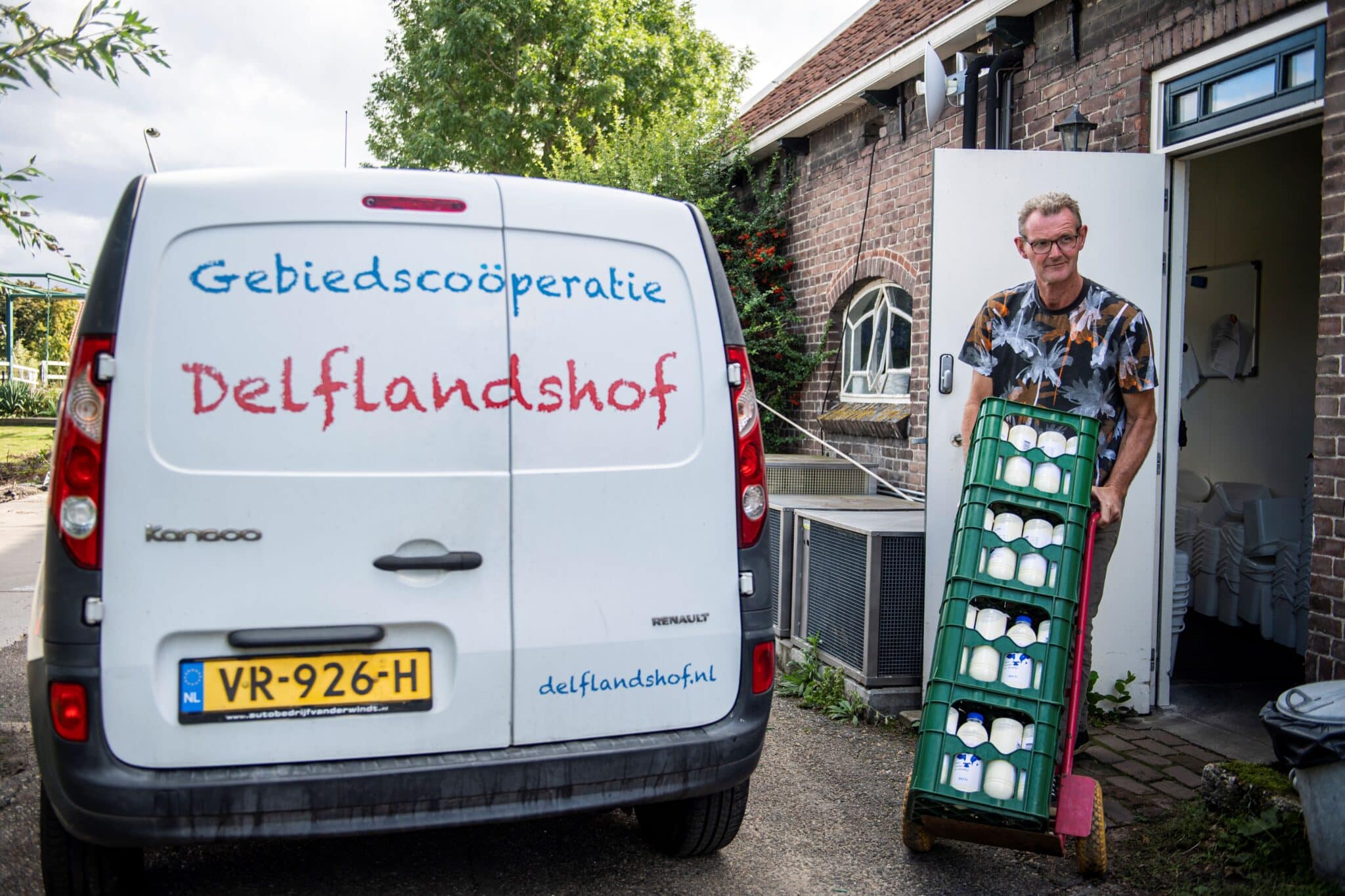 Bestelbus van Delflandshof wordt geladen met kratten zuivel